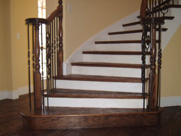 Circular wood staircase with iron balusters